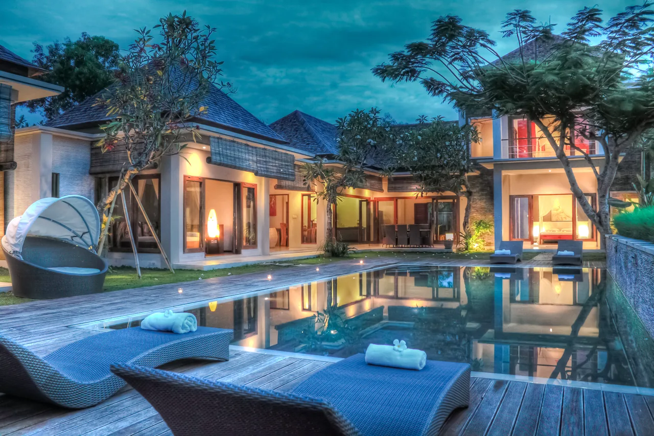 Tropical home and swimming pool illuminated in the evening